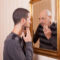 young man looking at an older himself in the mirror